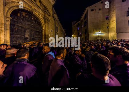 The Turbas de Cuenca have stayed awake through the night before Good Friday. In front of the parish church of El Salvador, they make enough noise to be heard throughout Cuenca for hours before the procession begins. Plaza Salvador, Cuenca, Castilla-La Mancha, Spain. The Turbas tradition dates back to their first procession on 4 April 1616. Members, known as turbos, wear the robes of their brotherhoods and play homemade drums and tin trumpets. The trumpets' off-key sound is called clariná, the drumbeat palillá. During Semana Santa in Cuenca, 33 Hermandades take part in eleven processions throug Stock Photo