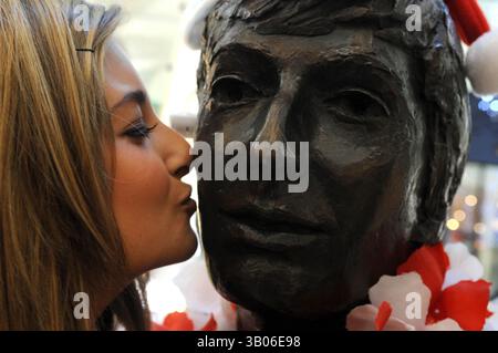 Dec 08, 2010 - Liverpool, Merseyside, United Kingdom - Prayer vigil at the Beatles statue in Cavern Walks, Mathew Street, Liverpool where Reverend Brookes conducted prayers in honour of 30 years since John Lennon was shot and Killed in New York. Pictured here is Beatles fan Natalie Stuart, 21, from Liverpool kissing the face of John Lennon (Credit Image: © Mercury Press/ZUMAPRESS.com) Stock Photo