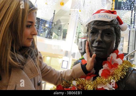 Dec 08, 2010 - Liverpool, Merseyside, United Kingdom - Prayer vigil at the Beatles statue in Cavern Walks, Mathew Street, Liverpool where Reverend Brookes conducted prayers in honour of 30 years since John Lennon was shot and Killed in New York. Pictured here is Beatles fan Natalie Stuart, 21, from Liverpool kissing the face of John Lennon (Credit Image: © Mercury Press/ZUMAPRESS.com) Stock Photo