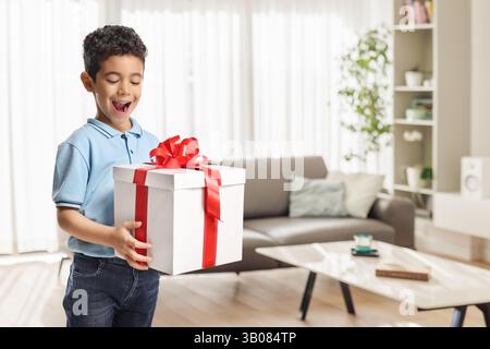 Cute asian boy looking at a big gift box at home Stock Photo