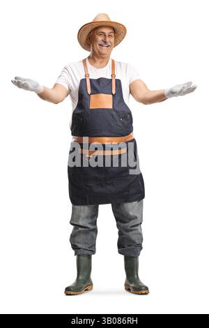 Full length portrait of a mature gardener with a straw hat and rubber boots isolated on white background Stock Photo