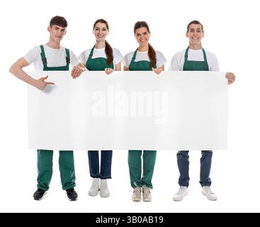 Team of cleaning service workers holding blank banner on white background. Space for text Stock Photo