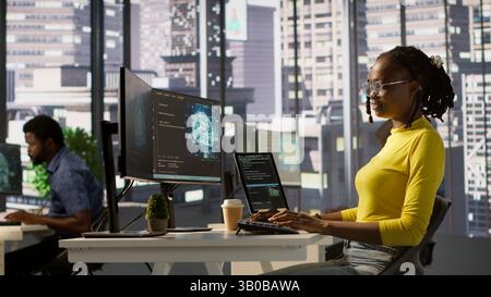 Software engineer conducts code review to fix bugs, identifying technical issues with artificial intelligence company software. African american woman debugging and optimizing code using AI, camera A Stock Photo