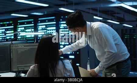 Computer scientists in data center managing and maintaining databases, ensuring data integrity and security. IT staff members updating server room systems using, camera A Stock Photo