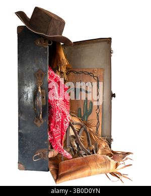 Antique suitcase, handle & latches is open with western gear wear tumbling out. Open antique suitcase stands on end with old cowboy western clothes. Stock Photo