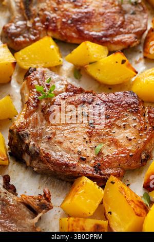 Pork chops and potatoes on a sheet pan oven roasted with herbs and spices for an easy dinner Stock Photo