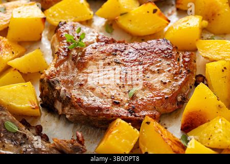 Pork chops and potatoes on a sheet pan oven roasted with herbs and spices for an easy dinner Stock Photo