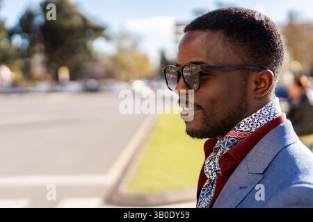 A Stylish Young Man Posing Confidently in a Vibrant Urban Setting Filled with Life Stock Photo