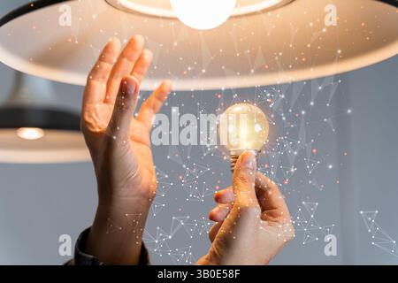 Hand of businessman holding illuminated light bulb with network connection line, idea, innovation and inspiration concept. Creativity with bulbs that Stock Photo