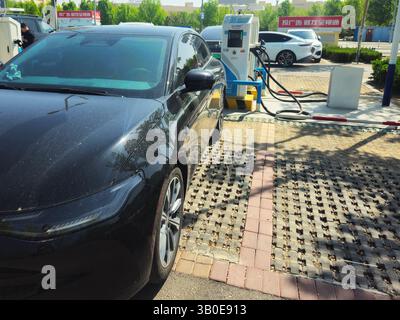 Electric Sedan Charging at Sinopec Recharge Station in Urban China Stock Photo