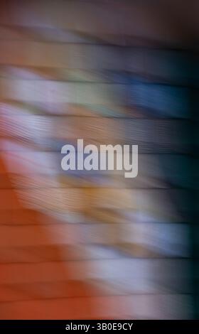 abstract motion blur of colorful painted wooden squares on building wall effect created by long time exposure and intentional camera movement or ICM Stock Photo