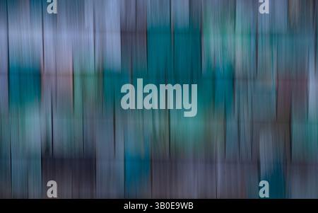 abstract blur of blue green and purple colored cedar wooden shakes or shingles on side of old abandoned building motion blur effect created by long Stock Photo