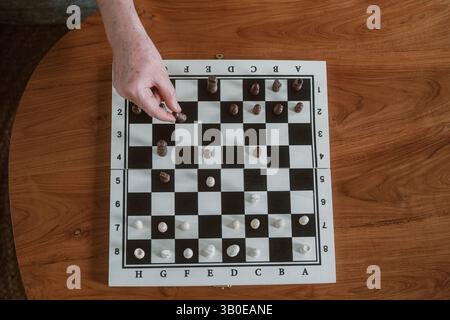 Top view close up of a senior woman hands making a move with a chess piece Stock Photo