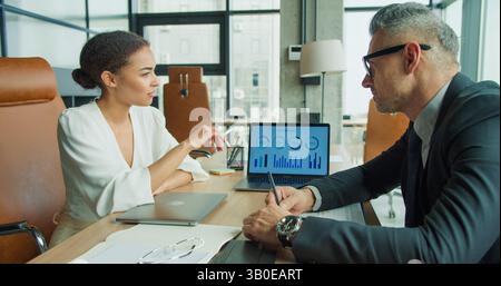 Business partners analyzing infographic data report Stock Photo