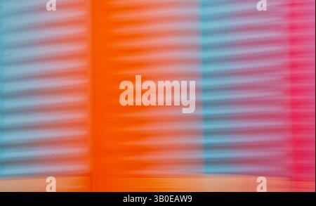 abstract blur of red orange and blue or turquoise corrugated metal special blurry effect created by long time exposure and intentional camera movement Stock Photo