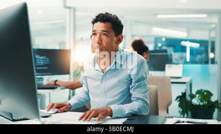 Programmer, man and reading computer in office for software development, typing code or app testing. Programming, employee and technology for database Stock Photo