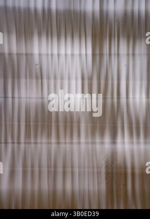 abstract blur monotone background of white or off white curtains in window with light coming in blurred by intentional camera movement long exposure Stock Photo