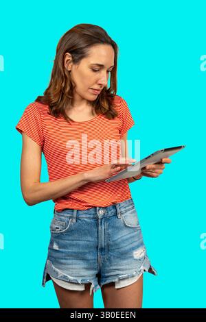 Casual dressed female using electronic device, browsing internet or reading e-book Stock Photo