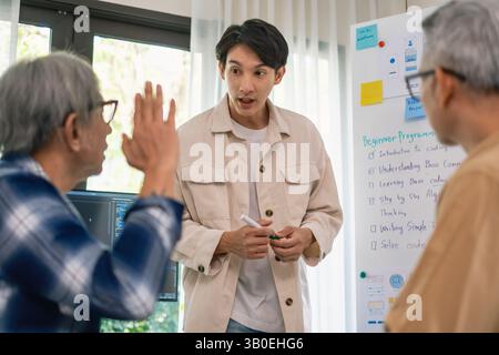 Asian senior bootcamp team asking and  learning programming with software training and whiteboard collaboration Stock Photo