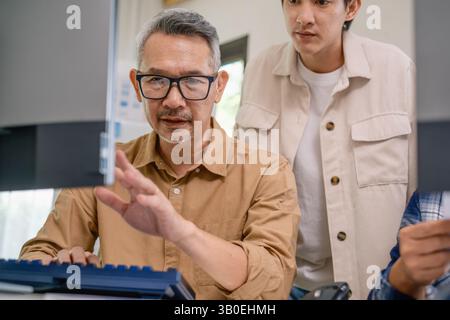 Asian senior bootcamp team asking and  learning programming with software training and whiteboard collaboration Stock Photo