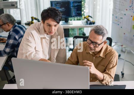 Group of asian senior in a collaborative software development analyzing  flowcharts  during a bootcamp training Stock Photo