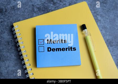 Concept of one person is answering question. he is choosing between merits over demerits write on sticky notes isolated on Wooden Table. Stock Photo