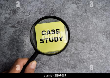 Concept of Case study with magnifying glass write on sticky notes isolated on Wooden Table. Stock Photo