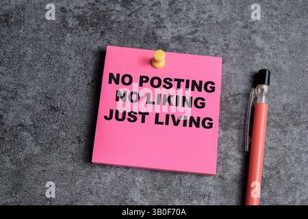 Concept of No posting, No liking, Just living write on sticky notes isolated on Wooden Table. Stock Photo