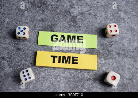 Concept of Game time write on sticky notes isolated on Wooden Table. Stock Photo