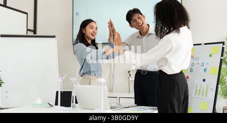 Teamwork and Collaboration. Three colleagues engaging in a high-energy brainstorming session focused on sustainability initiatives. Stock Photo