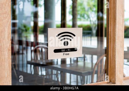 free Wi-Fi sign is posted on the glass door in front of the restaurant. Stock Photo
