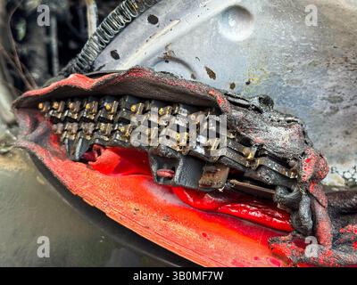 Close-up of a severely burned LED tail light module from a car, showing melted plastic housing, exposed electrical components, and heat-damaged intern Stock Photo