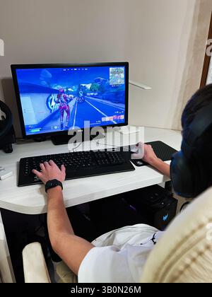 Kyiv, Ukraine - April 23, 2025: A gamer actively engaged in playing Fortnite video game on a personal computer setup. Stock Photo