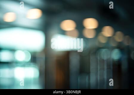 Blurry, defocused, large interior space with natural window light. Blue tint, moody, abstract bokeh background, no people. Stock Photo