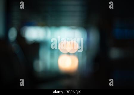 Blurry, defocused, large interior space with natural window light. Blue tint, moody, abstract bokeh background, no people. Stock Photo