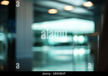 Blurry, defocused, large interior space with natural window light. Blue tint, moody, abstract bokeh background, no people. Stock Photo