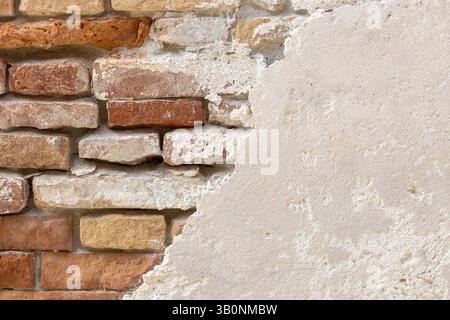 Old Brick Wall Revealed Under Plaster Stock Photo