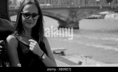 Young woman posing in Paris with Seine river and bridge in background Stock Photo