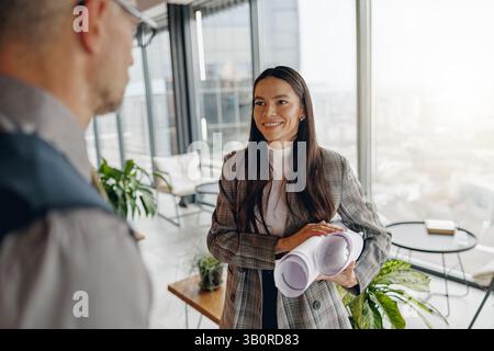 A dynamic business meeting taking place in a modern office setting featuring presentation materials Stock Photo