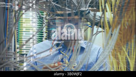 Image of data processing over biracial man inspecting server room Stock Photo