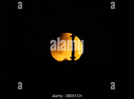 Partial lunar eclipse. The moon is visible behind the TV tower of Vitosha Mountain. Sofia, Bulgaria Stock Photo