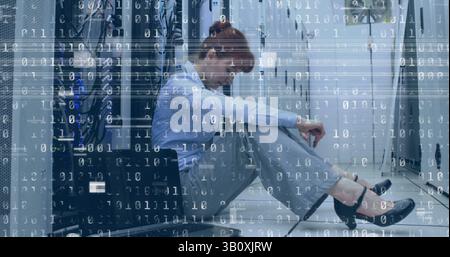 Image of interference and binary coding over caucasian woman in server room Stock Photo