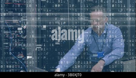 Image of interference and binary coding over caucasian man using laptop in server room Stock Photo