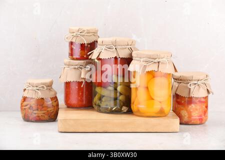 Many jars with different pickled products on light table Stock Photo