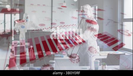 Two colleagues in protective suits studying virus data overlays in office, with laptops, sanitizer Stock Photo