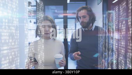 Screens with data processing against diverse male and female office colleagues discussing at office Stock Photo