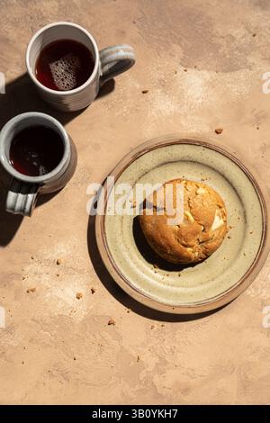 Chunky white chocolate cookie on a plate with two coffee cups. Stock Photo