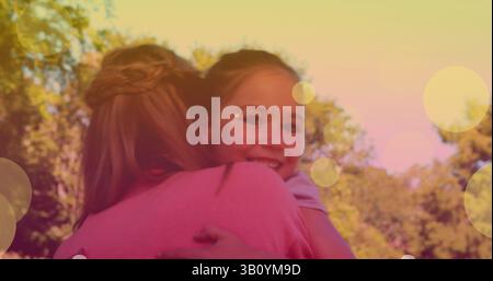 Image of bokeh over happy caucasian mother and daughter hugging Stock Photo
