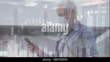 Image of financial data and graphs over caucasian senior man in face mask using smartphone Stock Photo
