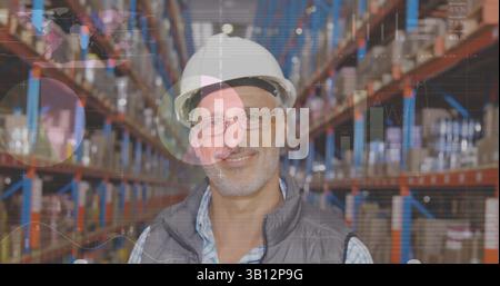 Image of statistics and data processing over smiling caucasian man working in warehouse Stock Photo